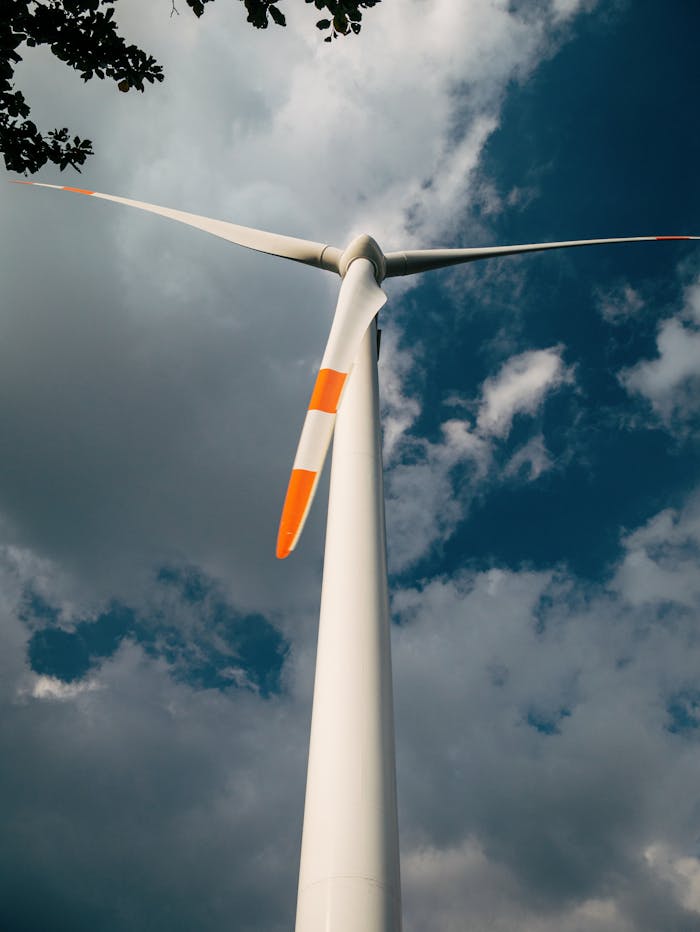 Close-up of a wind turbine and clouds, symbolizing clean energy solutions.